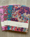 Set of three patterned notebooks on a wooden surface