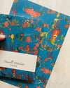 Two notebooks with mermaid design held by a hand on a light background